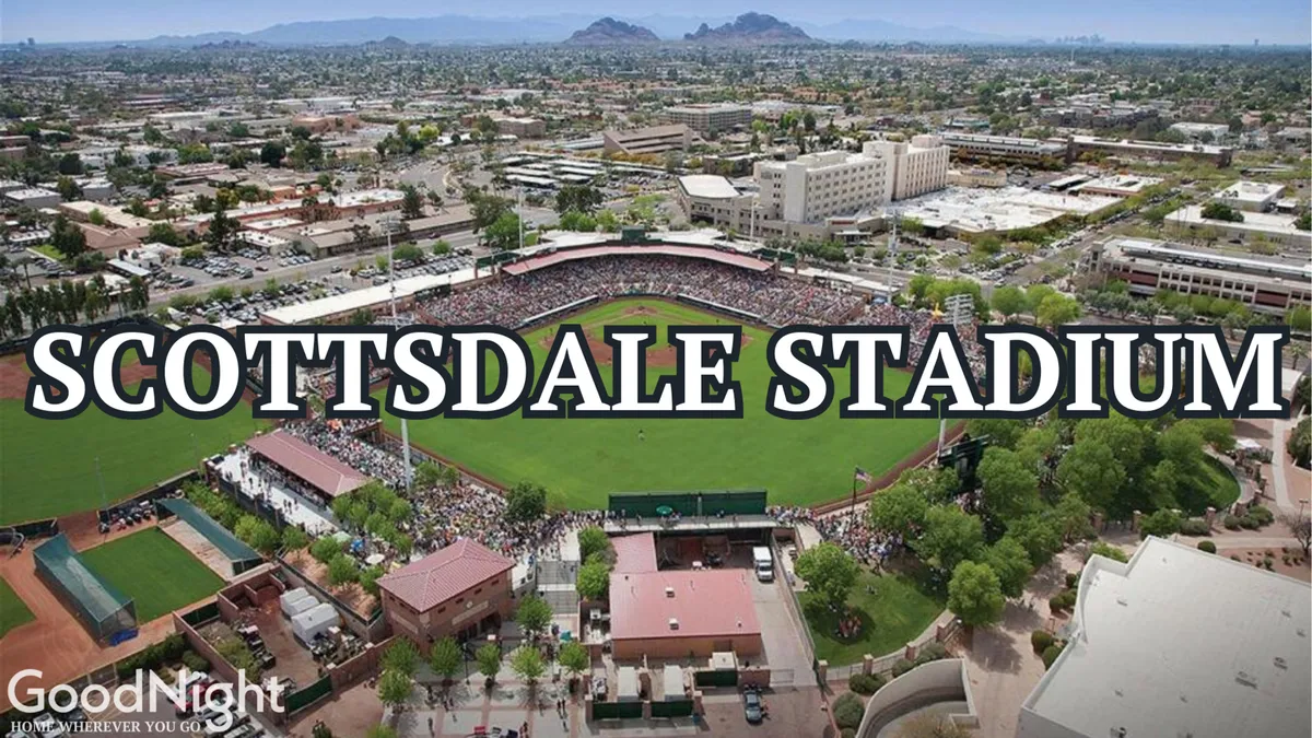 An exterior view of Scottsdale Stadium bustling with a crowd of people, the baseball field prominently displayed, with surrounding buildings in the backdrop. The lively atmosphere is palpable as fans gather to watch a baseball game and partake in local events.