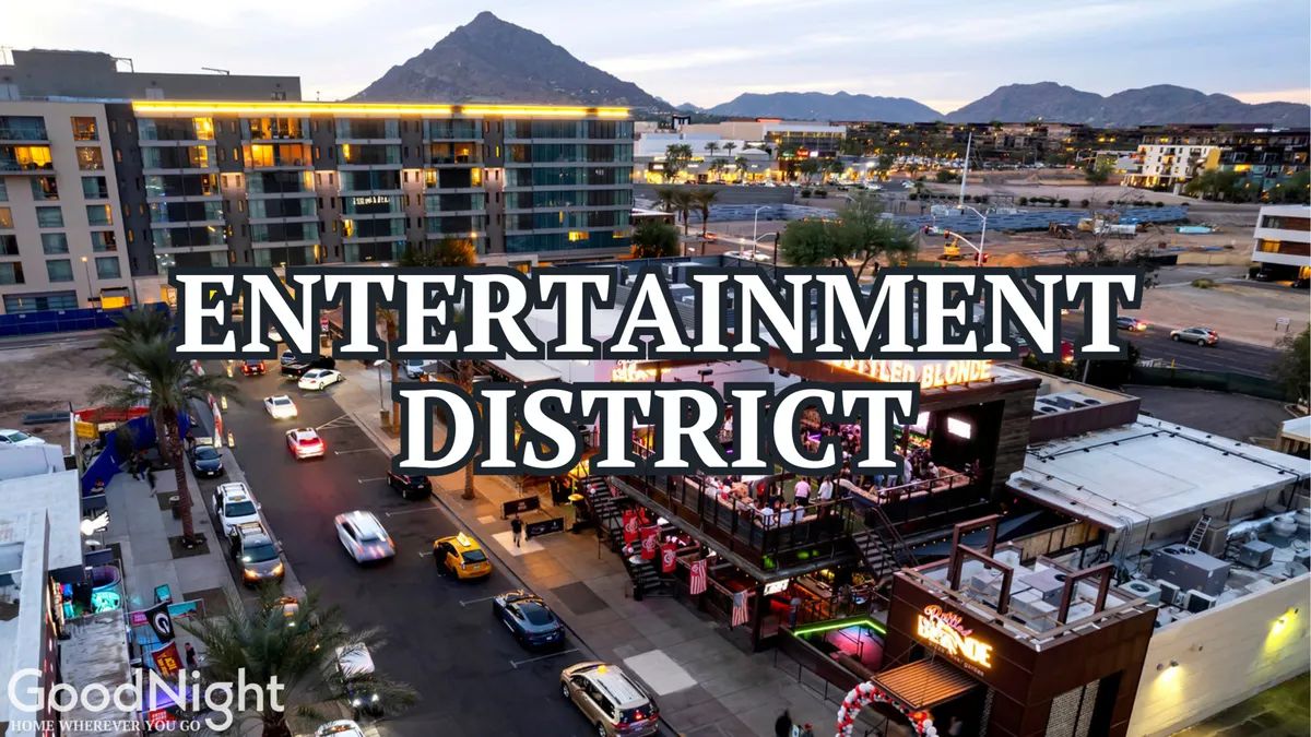 A lively street view of Scottsdale’s entertainment district, showcasing bustling entertainment venues, cars on the street, and mountains in the background. The scene exudes energy, hinting at live music, food festivals, and social gatherings.