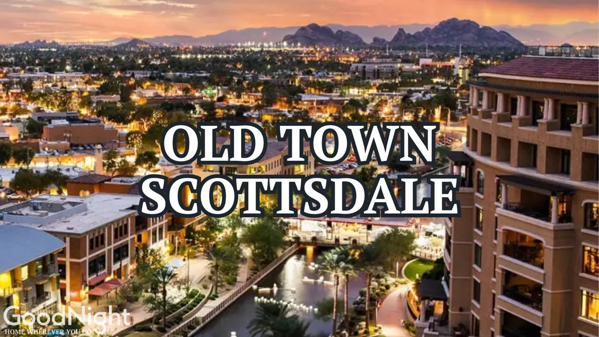 A sweeping cityscape at dusk featuring a vibrant water feature, illuminated buildings, and the silhouette of mountains in the background. People can be seen enjoying patios, boutique shopping, and lively night scenes, all captured in an inviting, energetic atmosphere.